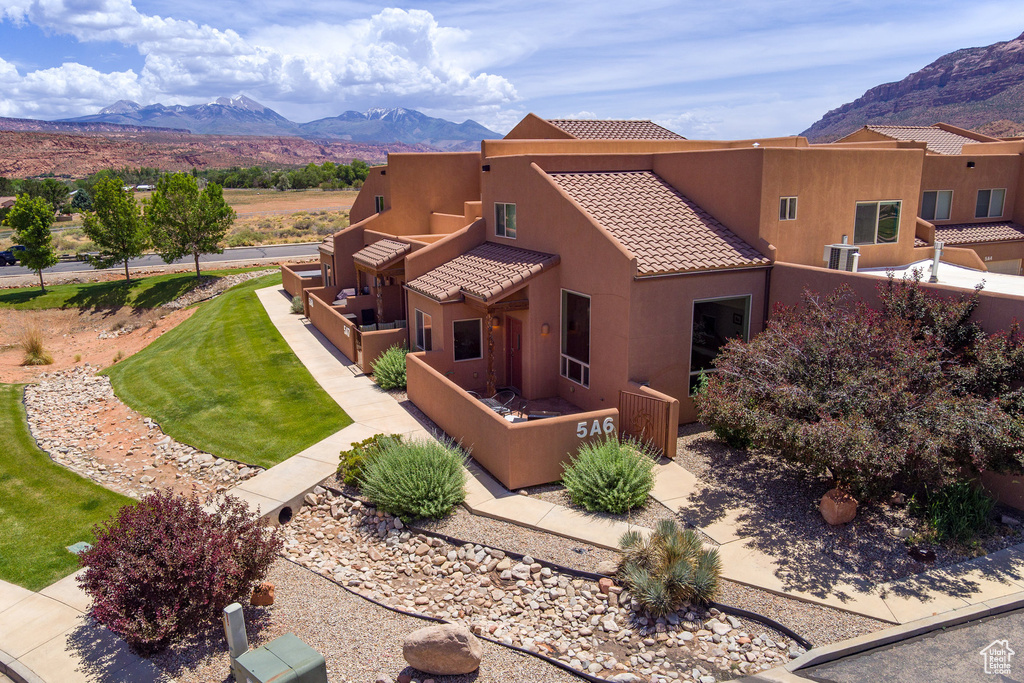 View of front facade with a mountain view, stucco siding, and a tile roof