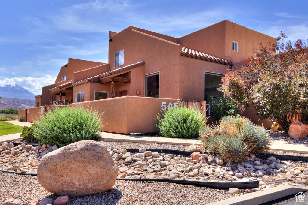 View of side of home featuring stucco siding and a mountain view