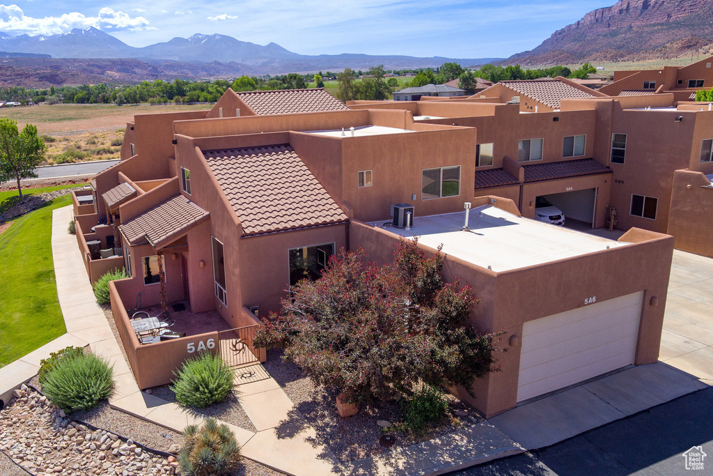 Aerial view of property and surrounding area with a mountain backdrop