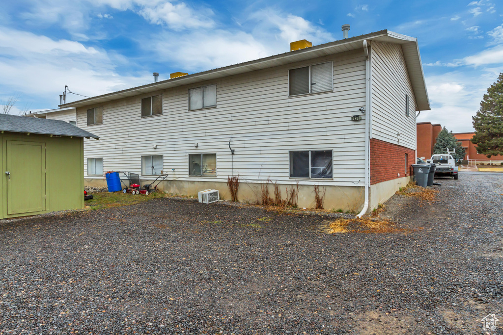 Back of property featuring a storage shed and a chimney