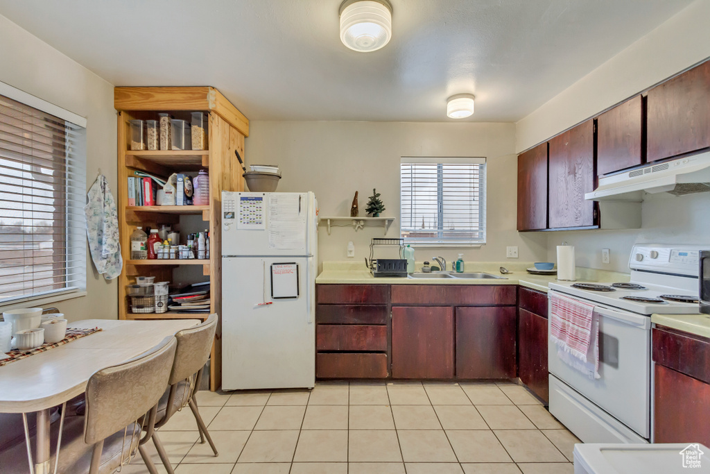 Kitchen featuring white appliances, under cabinet range hood, open shelves, light tile patterned floors, and light countertops