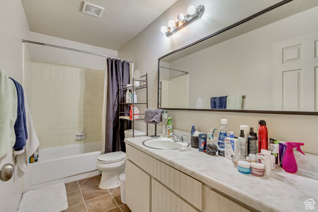 Bathroom with shower / bath combo with shower curtain, tile patterned flooring, and vanity