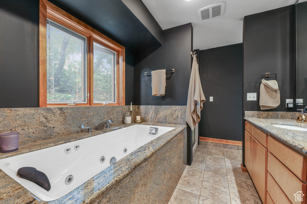 Full bathroom with vanity and a tub with jets