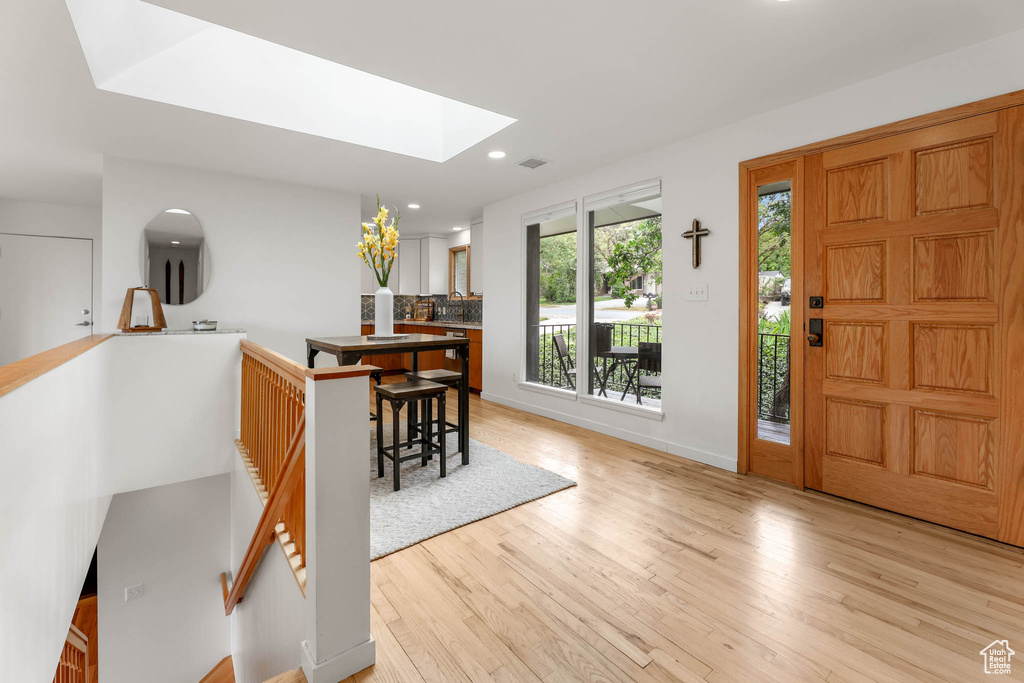 Foyer entrance featuring a skylight, light wood-type flooring, and recessed lighting