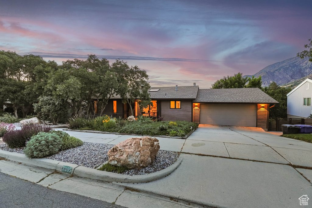 View of front of home with driveway, an attached garage, and a mountain view