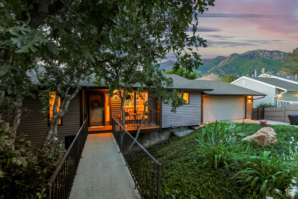 View of front of property featuring a garage, a mountain view, and a shingled roof