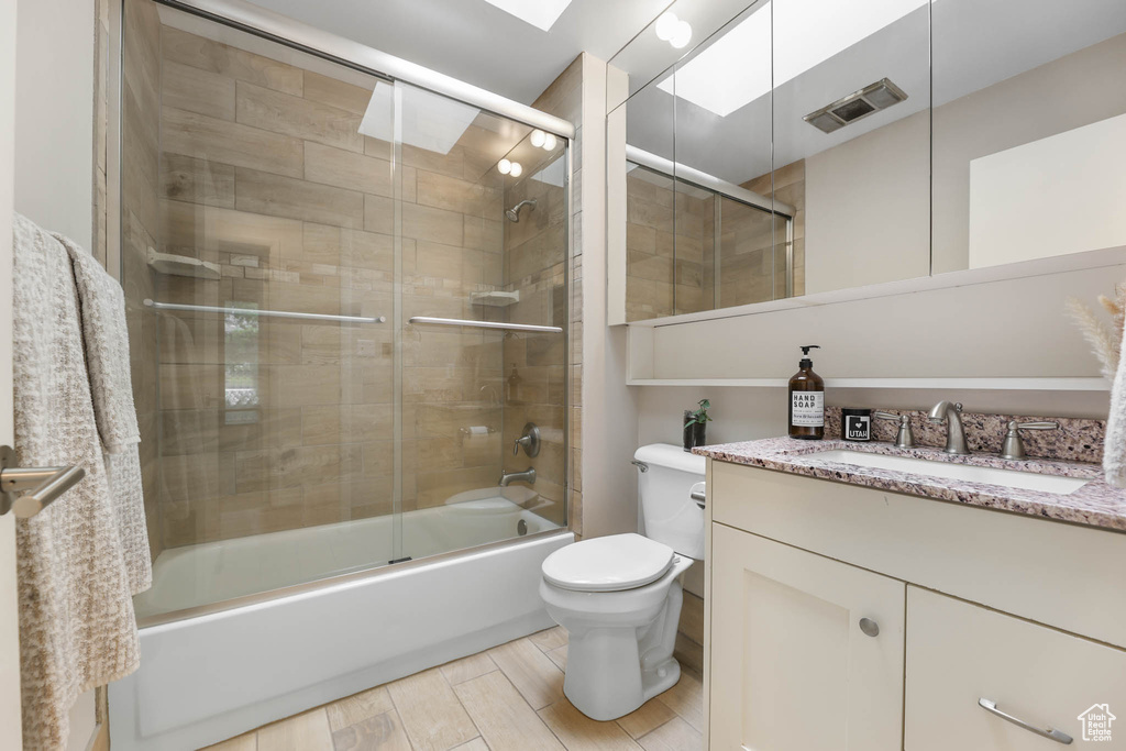 Full bath with vanity and combined bath / shower with glass door