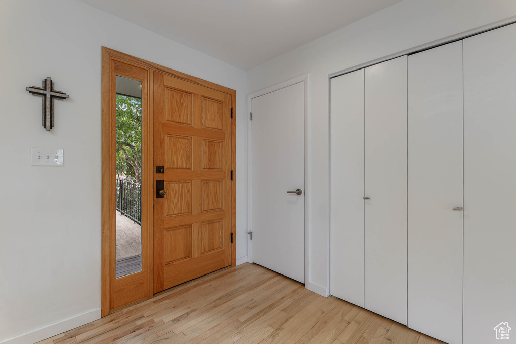 Foyer entrance with light wood finished floors and baseboards