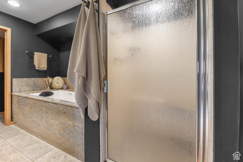 Full bath with a stall shower, a bath, and tile patterned floors