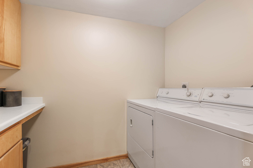 Washroom with washer and clothes dryer and cabinet space