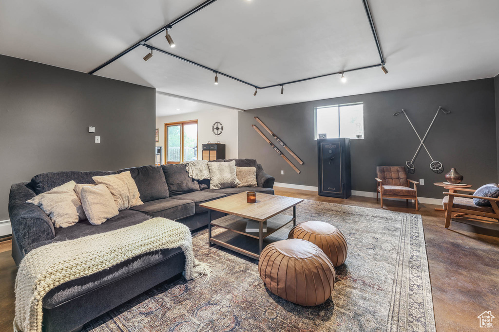 Living area featuring rail lighting, healthy amount of natural light, and concrete flooring