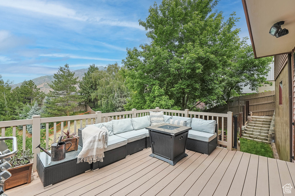 Deck featuring an outdoor living space with a fire pit and a mountain view