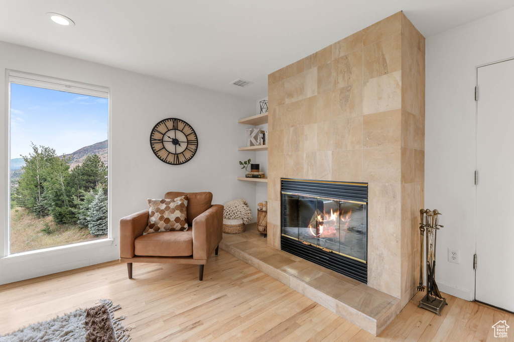 Living area with a tile fireplace, wood finished floors, recessed lighting, and a mountain view