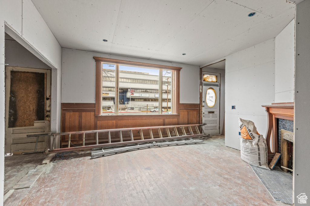 Unfurnished living room featuring wainscoting and wooden walls