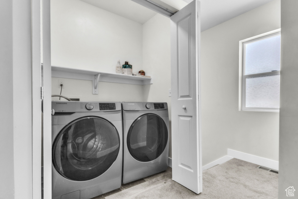 Washroom featuring independent washer and dryer and carpet flooring