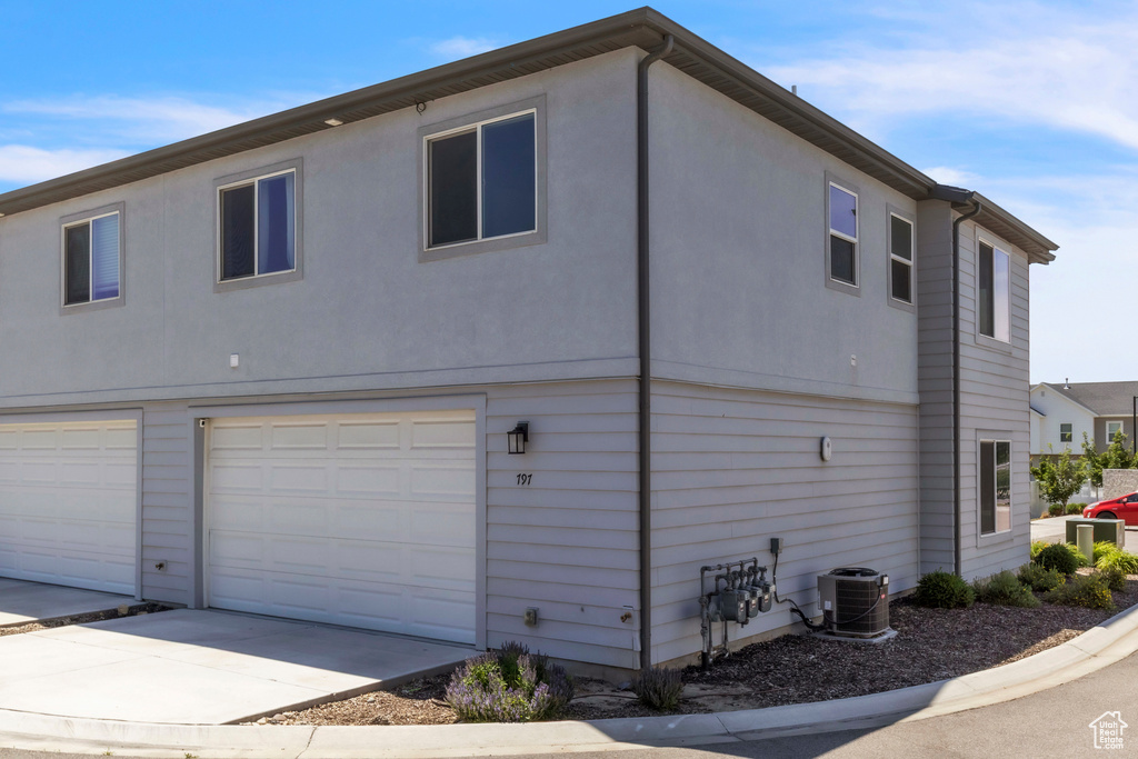 View of side of property with an attached garage and concrete driveway