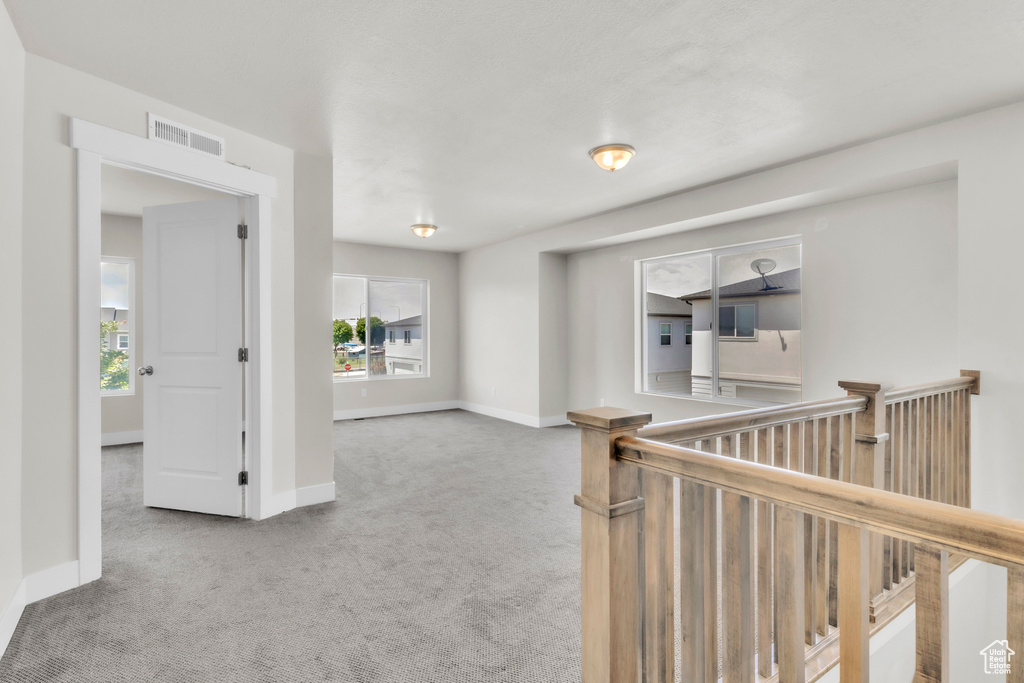 Corridor with carpet flooring and an upstairs landing