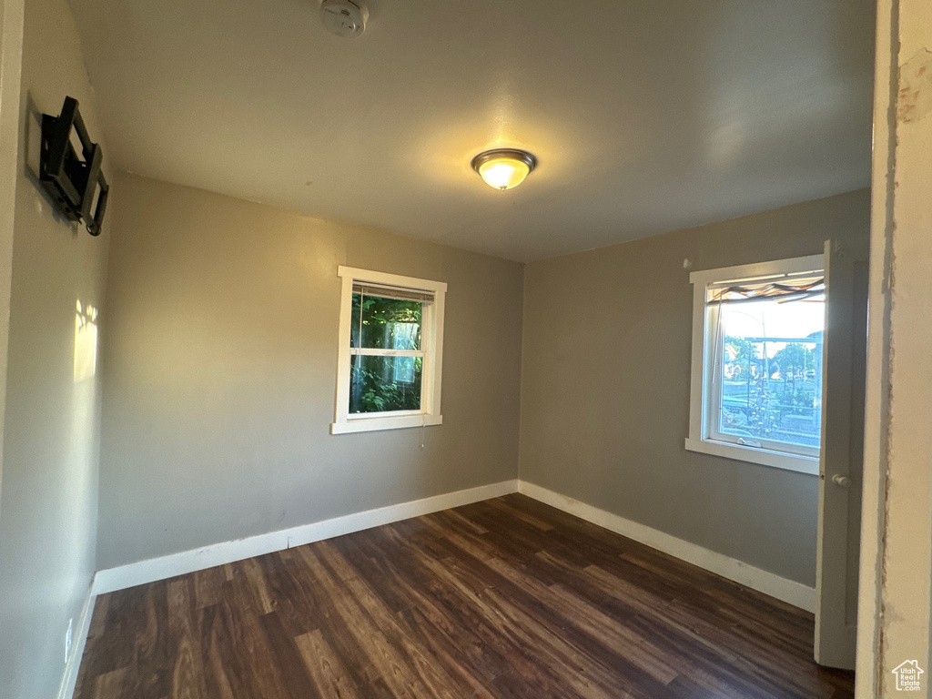 Unfurnished room featuring plenty of natural light and dark wood-style floors