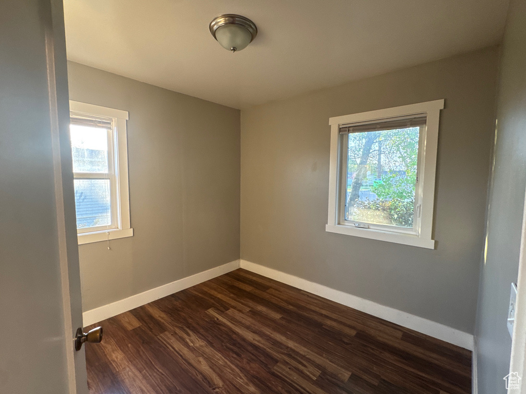 Spare room with dark wood finished floors and baseboards