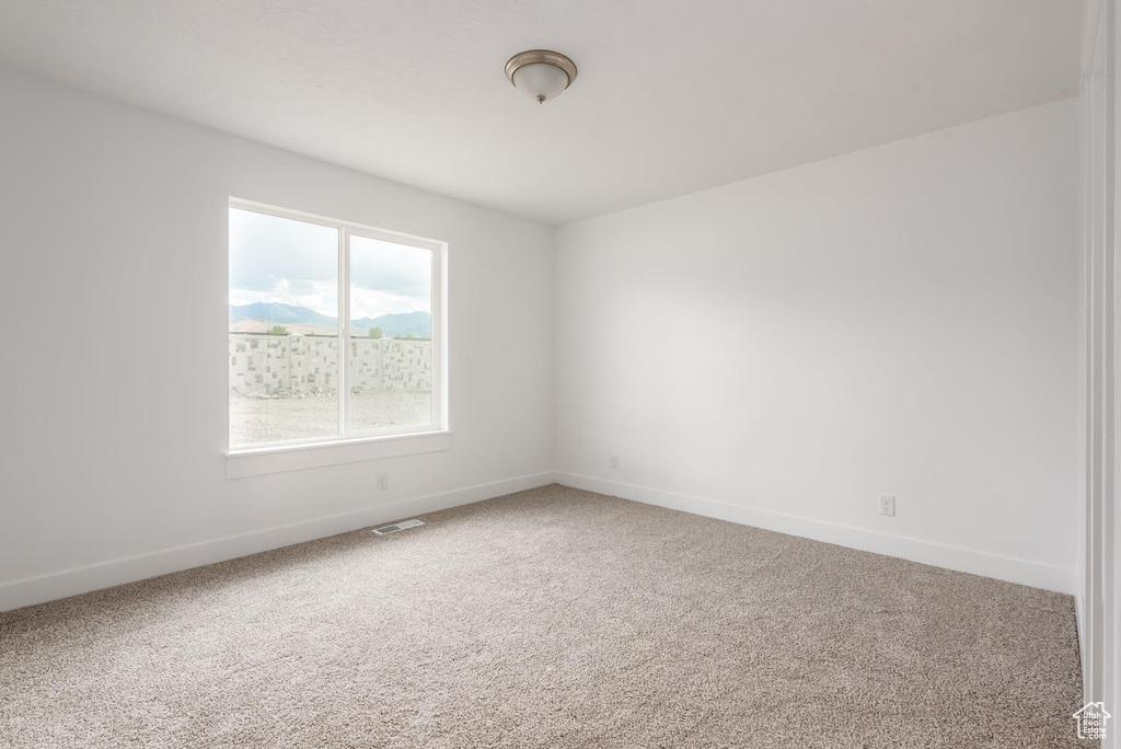 Empty room featuring carpet floors and baseboards