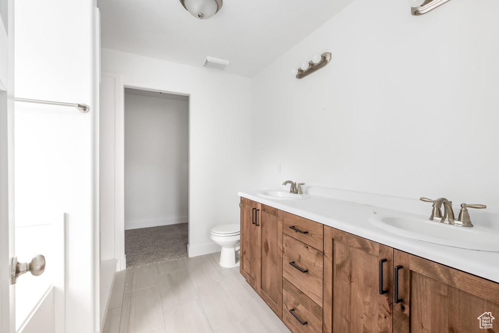 Bathroom featuring double vanity and toilet