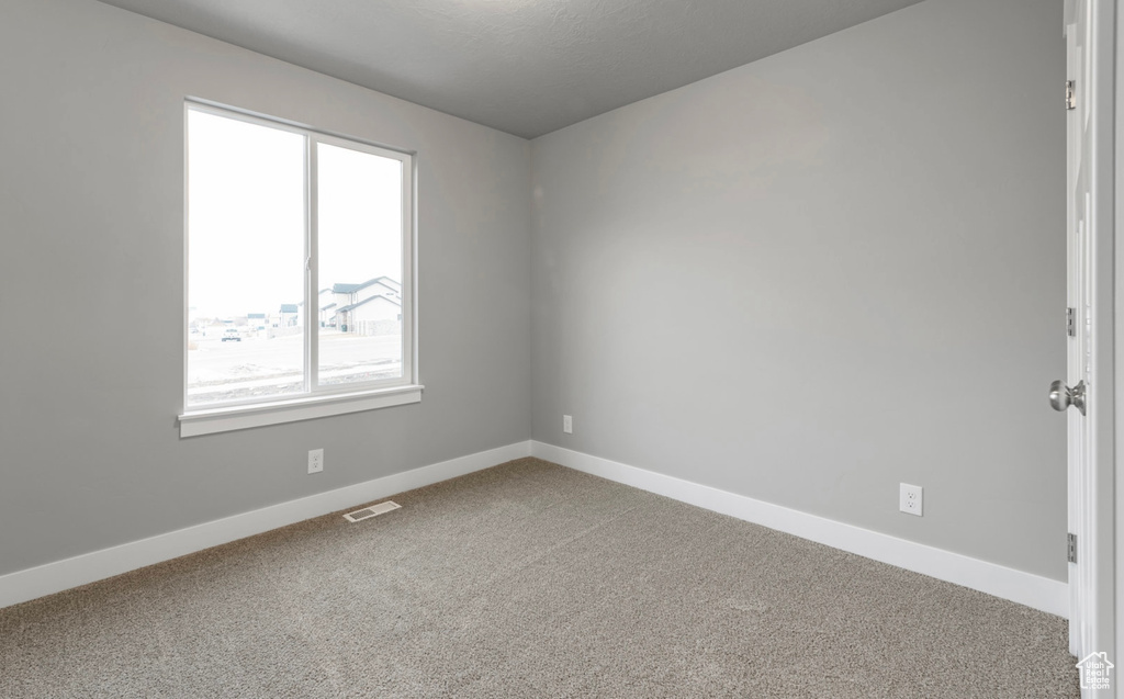 Carpeted empty room featuring baseboards