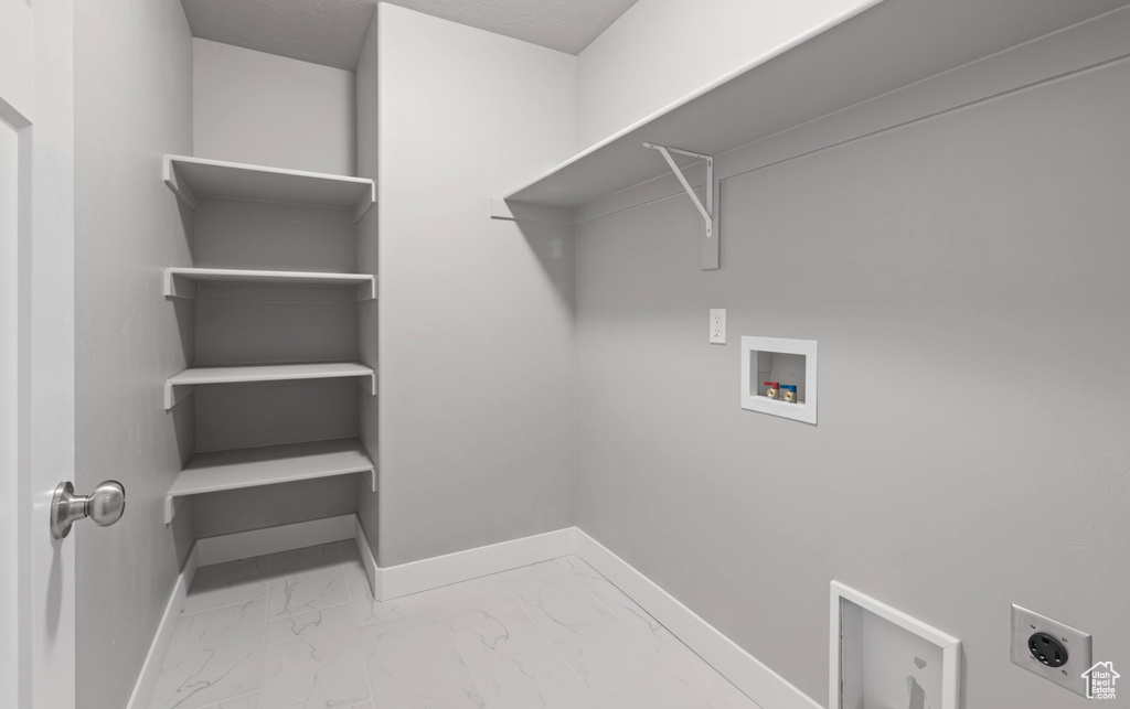 Laundry room featuring hookup for an electric dryer, washer hookup, and marble finish flooring