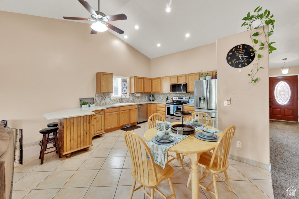 Dining room featuring a ceiling fan, high vaulted ceiling, light tile patterned floors, and recessed lighting