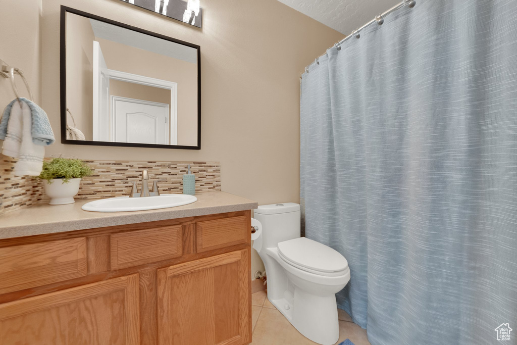 Full bathroom featuring backsplash, vanity, tile patterned flooring, and curtained shower