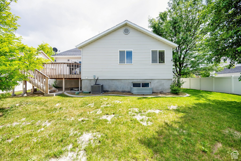 Rear view of property featuring stairs and a deck