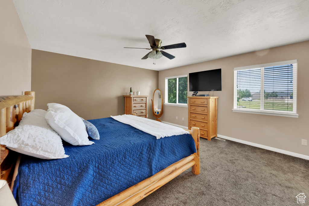 Carpeted bedroom featuring baseboards and ceiling fan