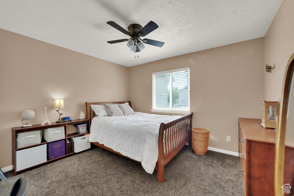 Carpeted bedroom featuring baseboards and ceiling fan