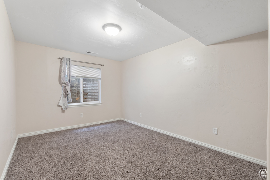 Unfurnished room featuring carpet and baseboards