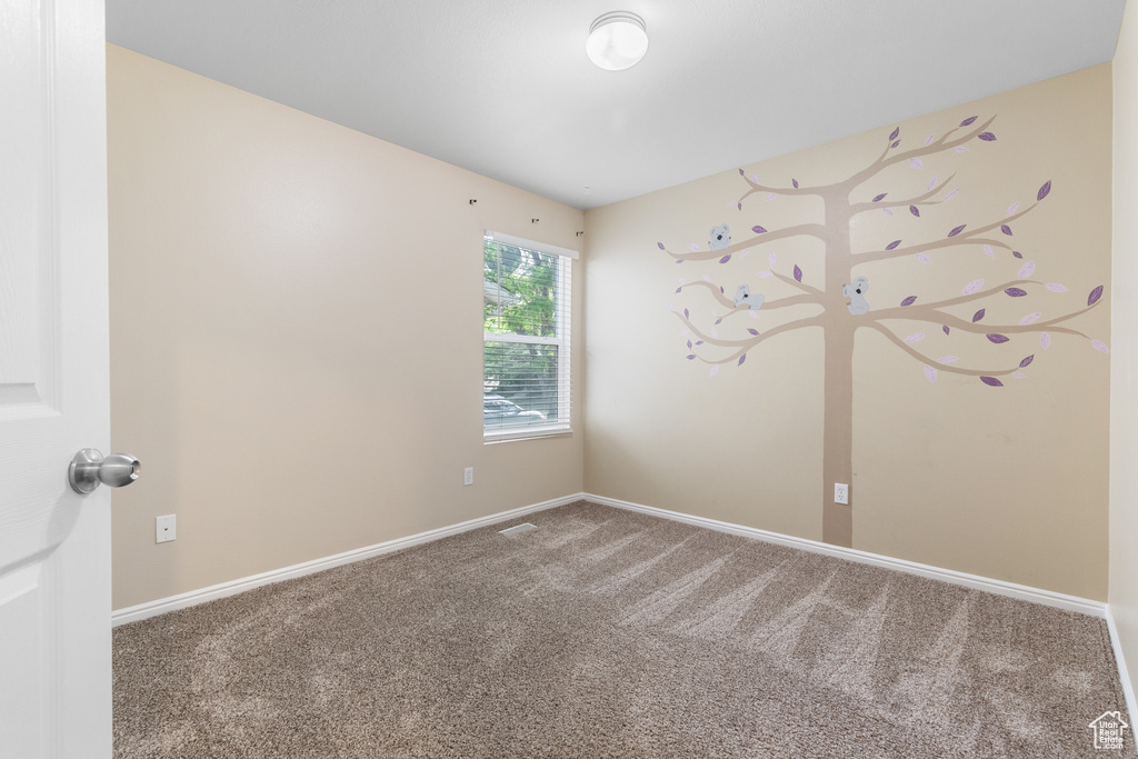 Carpeted empty room with baseboards