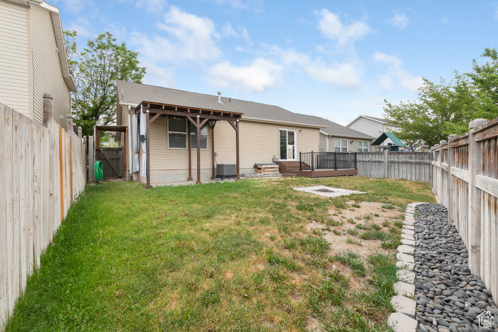 Rear view of house with a fenced backyard, a deck, and a gate