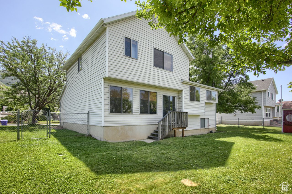 Rear view of house with a fenced backyard and a gate