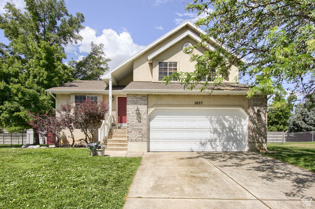 View of front of home featuring stucco siding, concrete driveway, and an attached garage