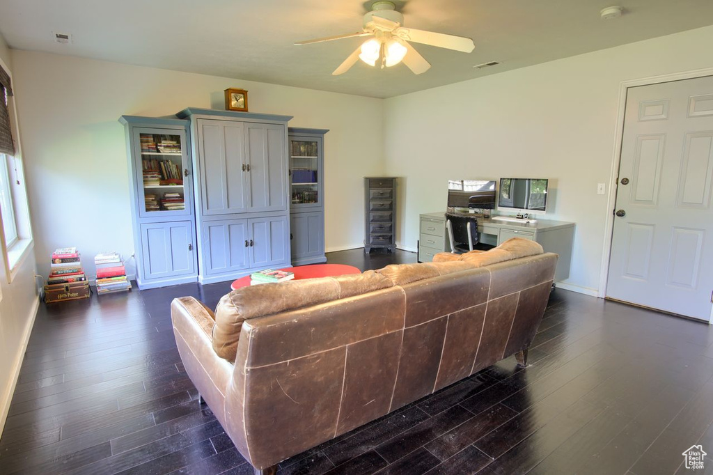 Living area featuring dark wood finished floors and ceiling fan
