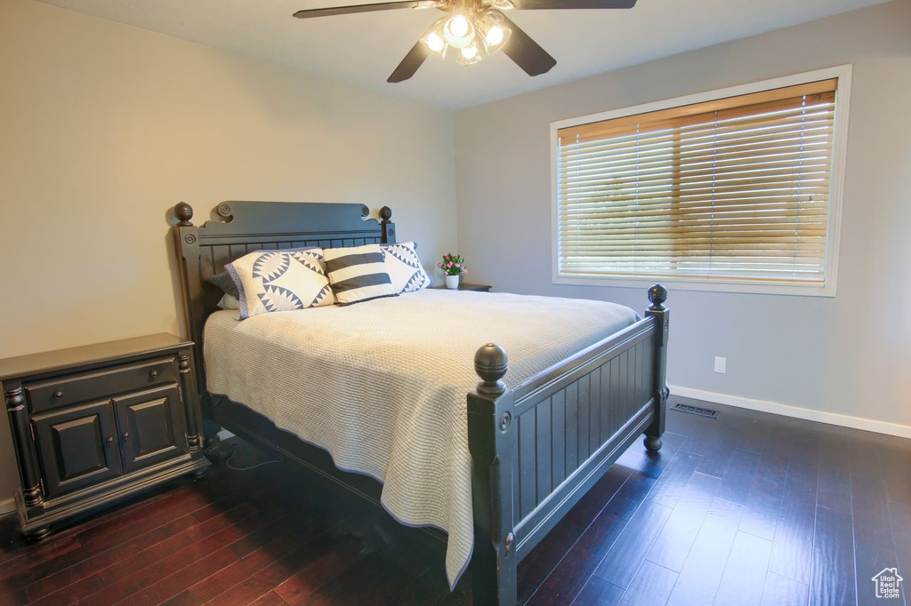 Bedroom with dark wood-type flooring and a ceiling fan