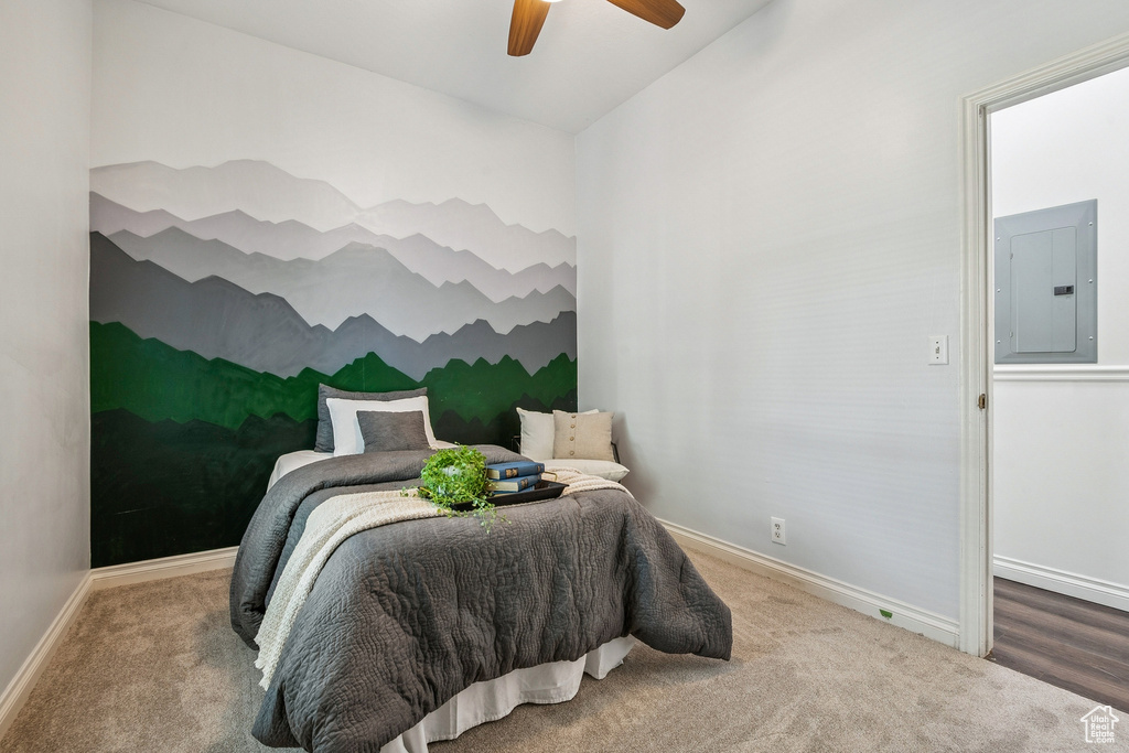Carpeted bedroom featuring electric panel and ceiling fan