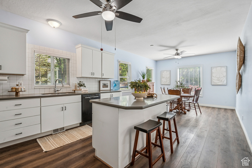 Kitchen with dishwasher, dark countertops, a ceiling fan, and a textured ceiling