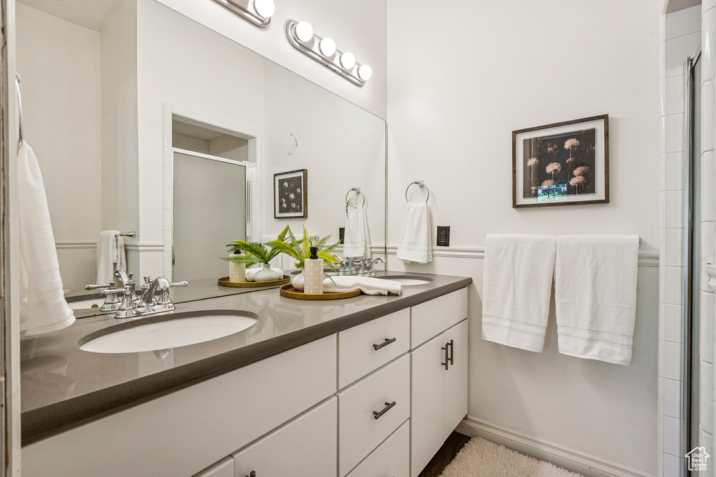 Bathroom featuring double vanity and a stall shower