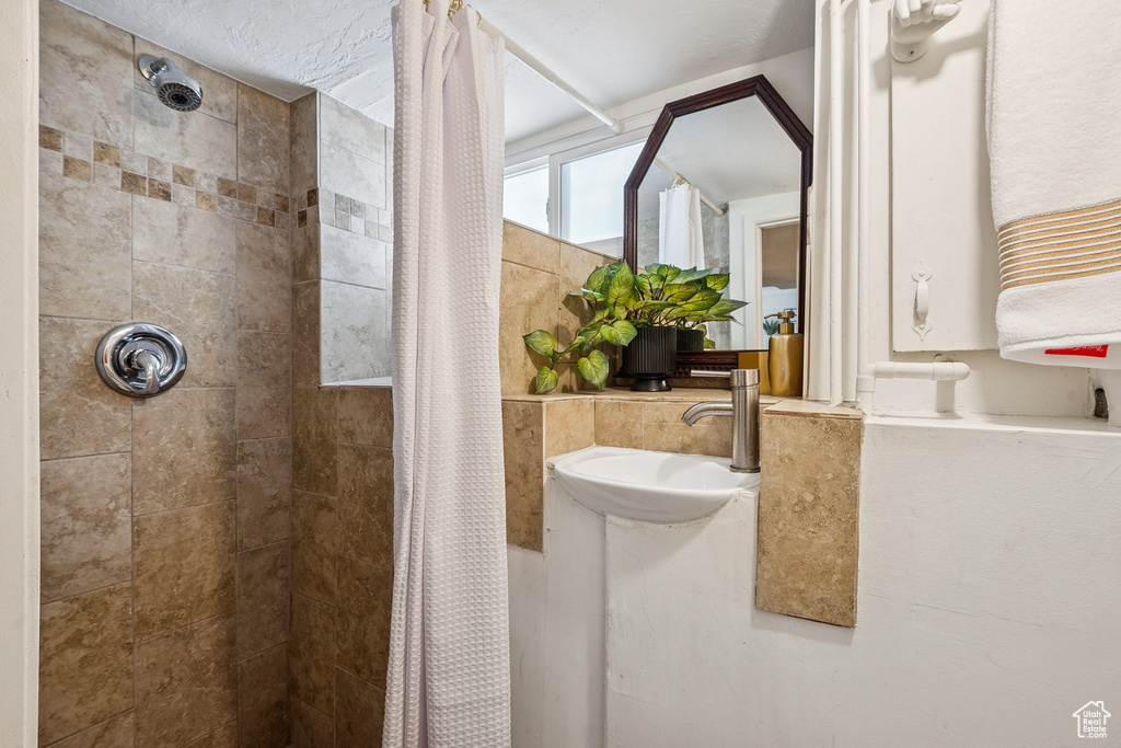 Bathroom with tiled shower and a sink