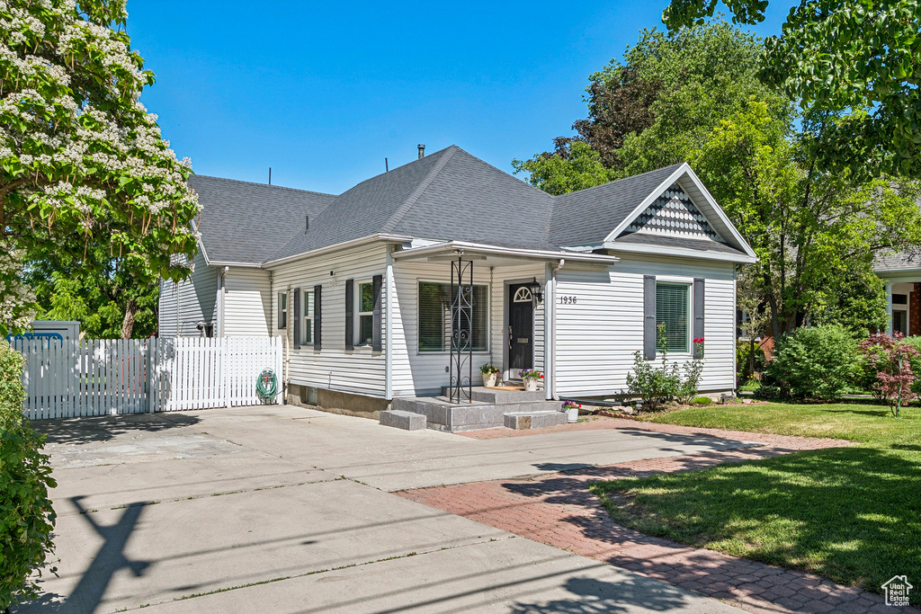 Back of property with a shingled roof and driveway