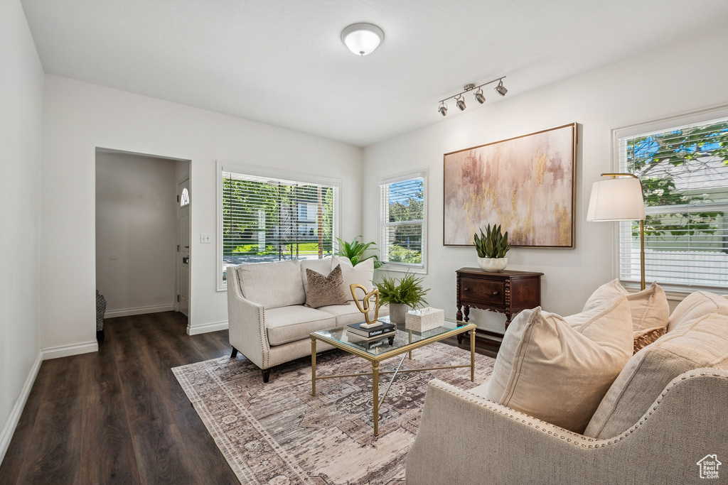 Living room with dark wood-style floors and healthy amount of natural light