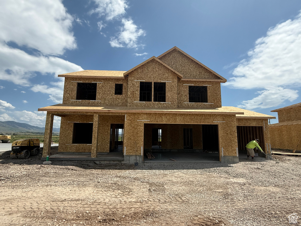 View of front of property with driveway, a garage, and a mountain view
