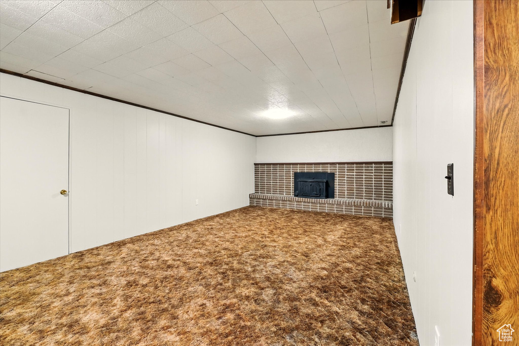 Finished below grade area featuring a brick fireplace and carpet flooring