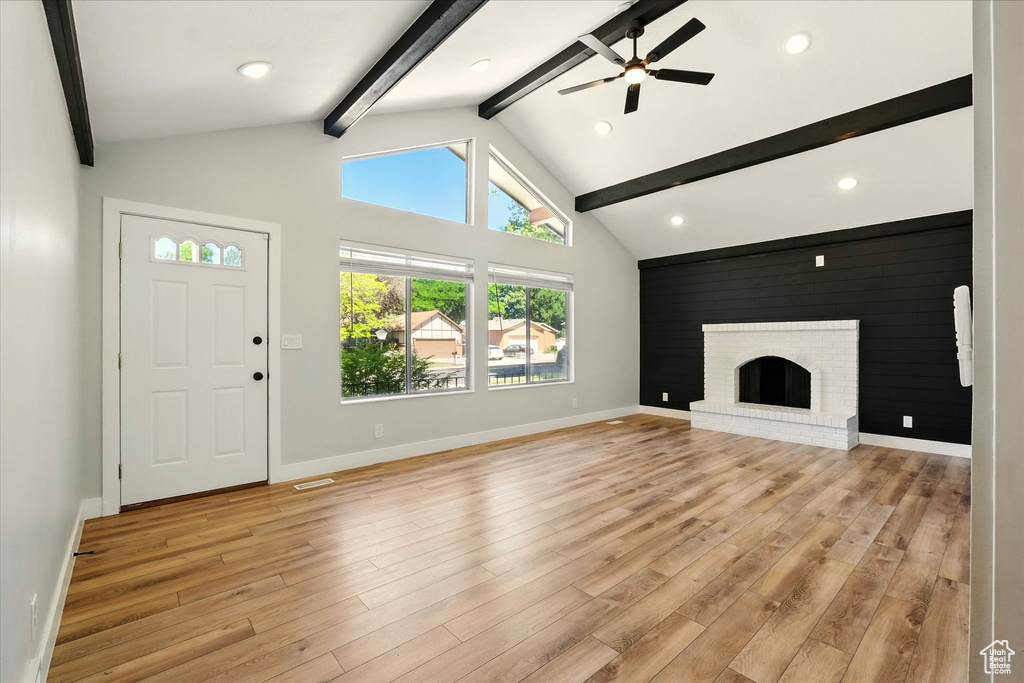Unfurnished living room with a ceiling fan, light wood-style floors, a brick fireplace, and recessed lighting