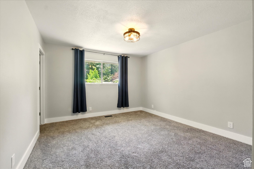 Spare room with a textured ceiling and carpet flooring