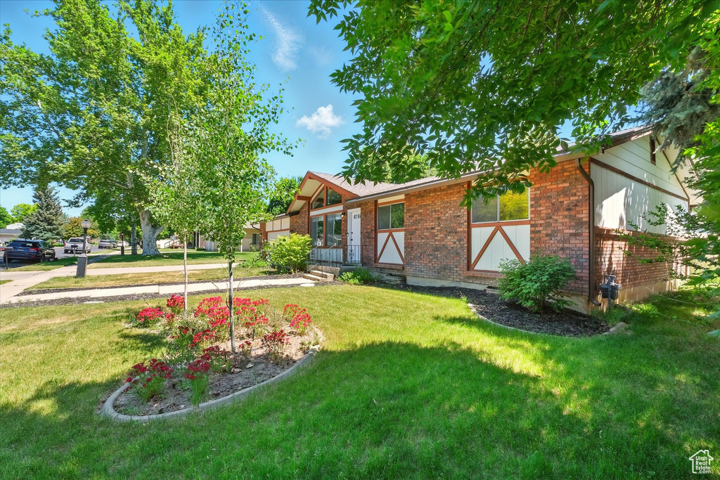View of front of home featuring brick siding and a front yard